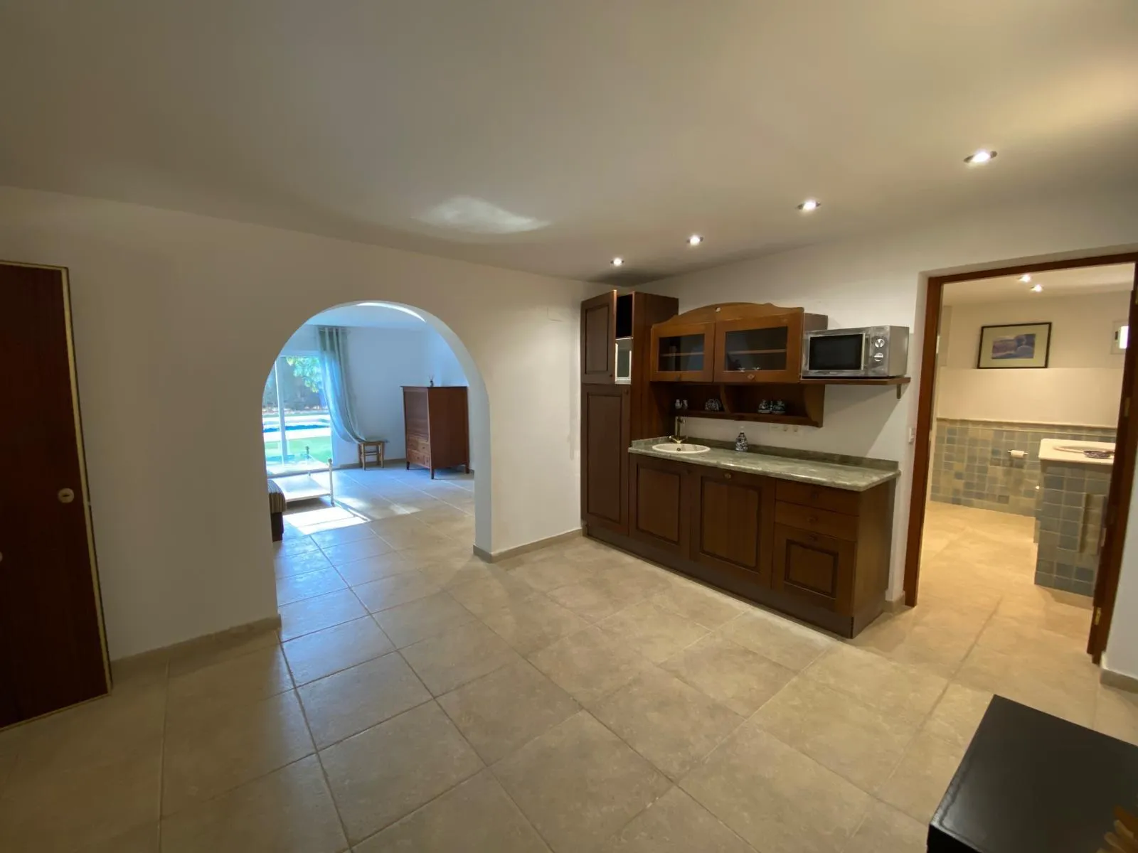 Cocina de la planta inferior con arco de paso al jardín