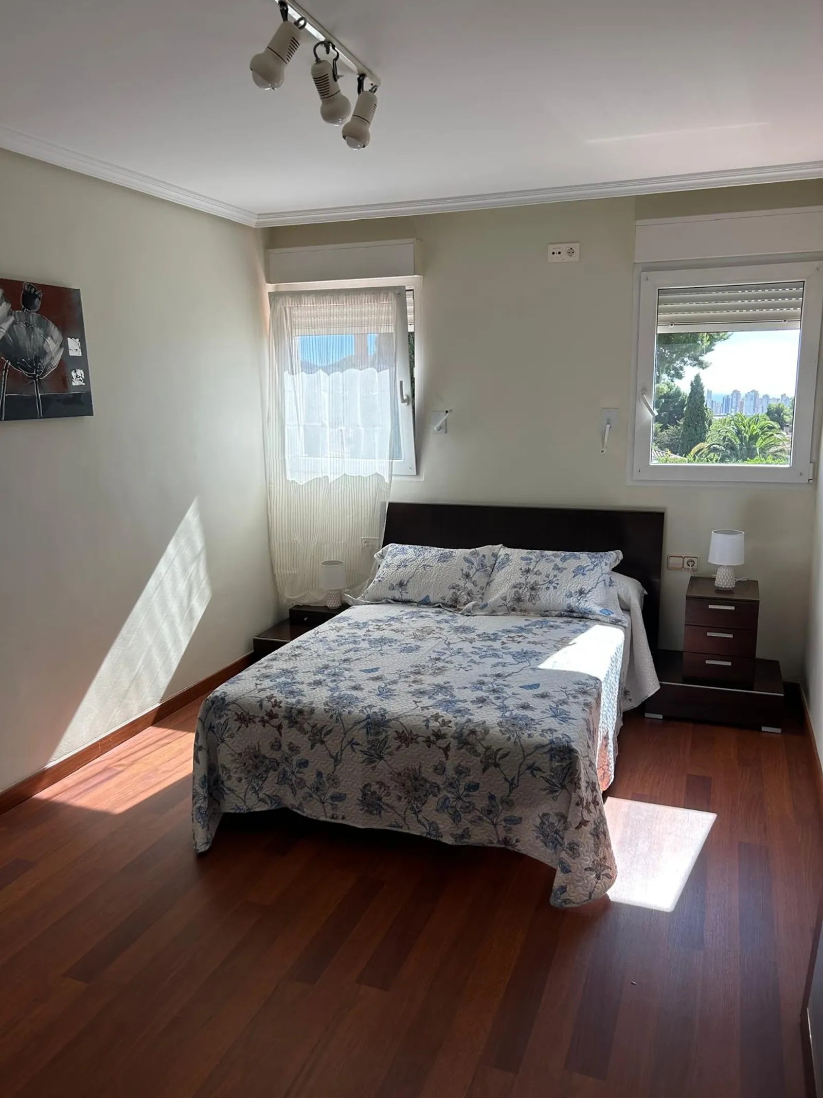 Dormitorio doble con suelo de madera y luz natural