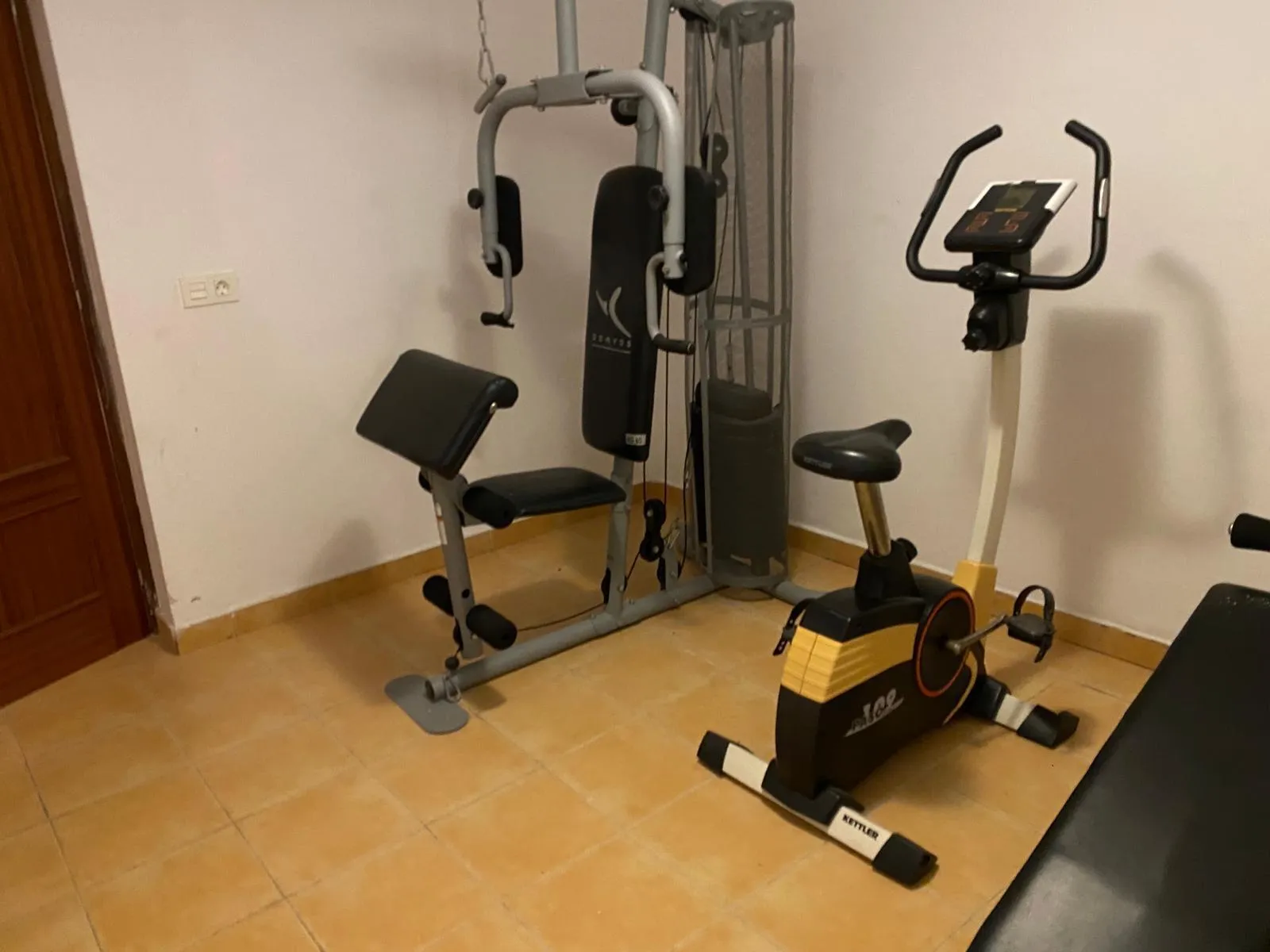 Gimnasio privado con máquina de musculación y bicicleta estática