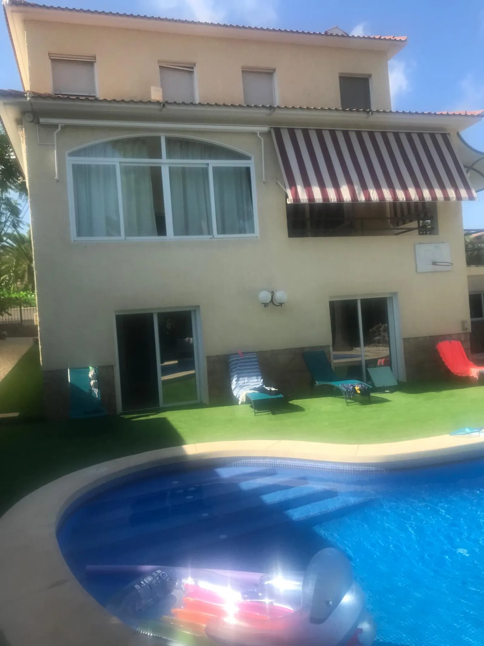 Piscina y solárium junto a la fachada del chalet independiente en Benidorm