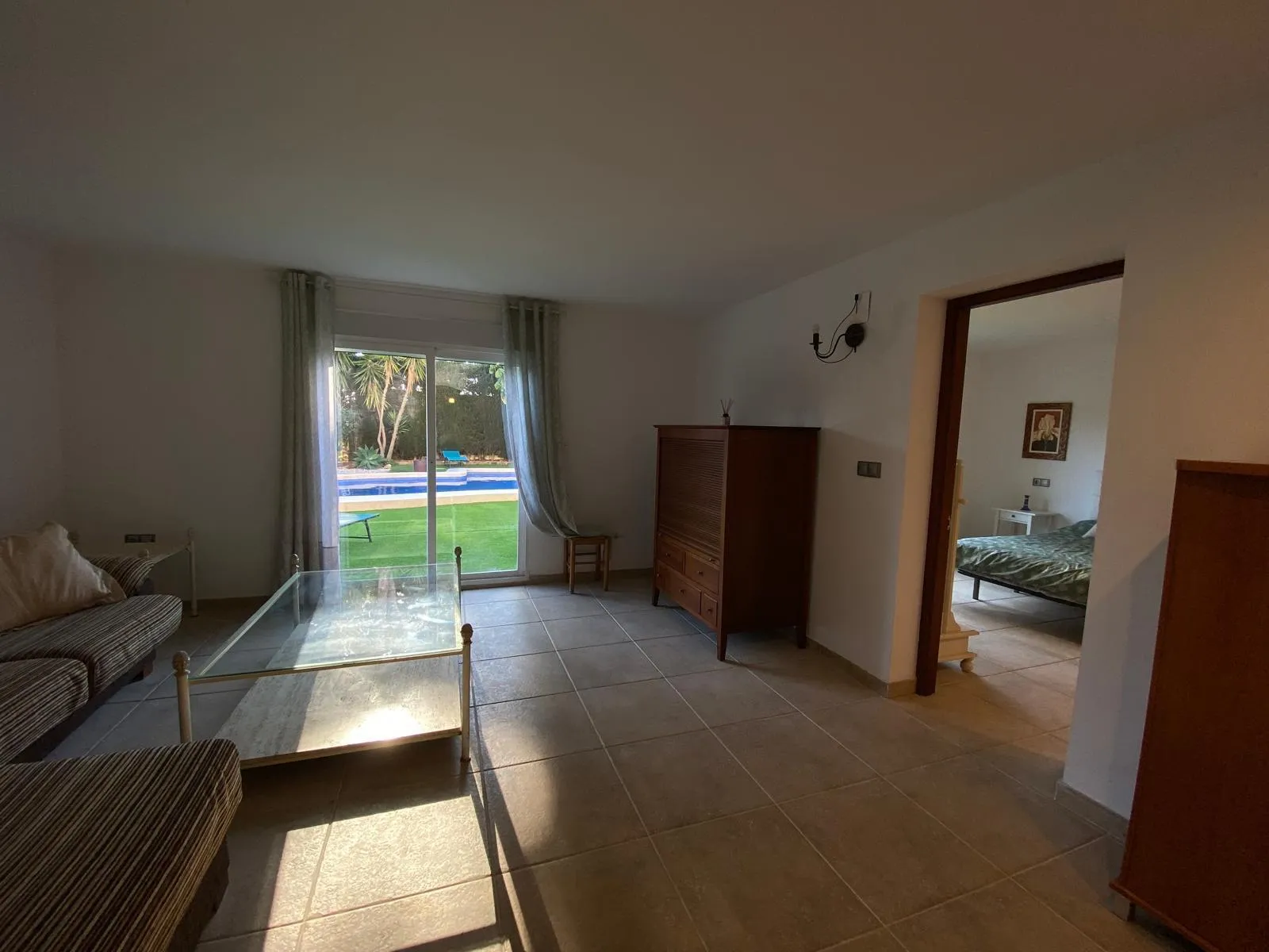 Estar de la planta inferior abierto a la piscina y al jardín