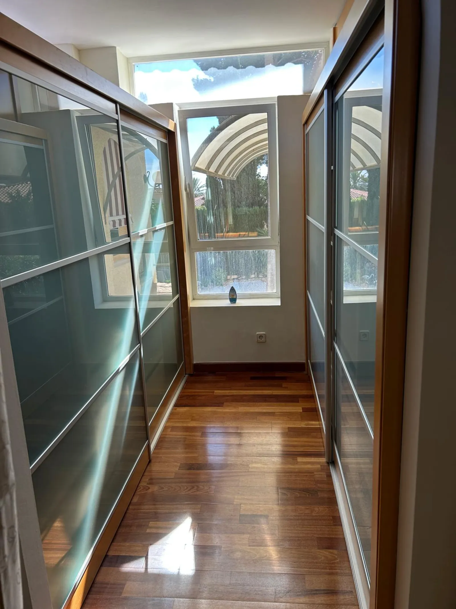 Pasillo vestidor con armarios empotrados de puertas correderas