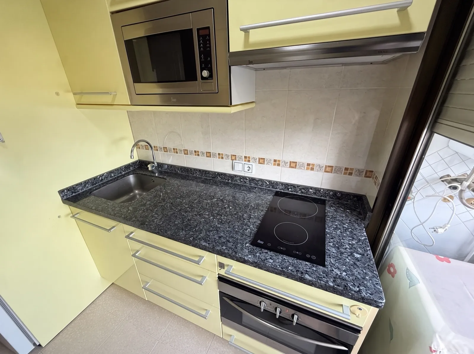 Cocina con placa vitrocerámica, horno y microondas en el piso de Coblanca 28