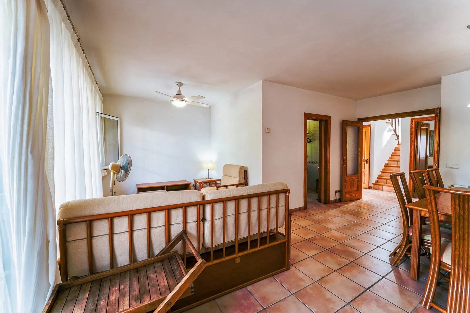 Salón con suelo de barro y cortinas blancas de la vivienda en Calpe